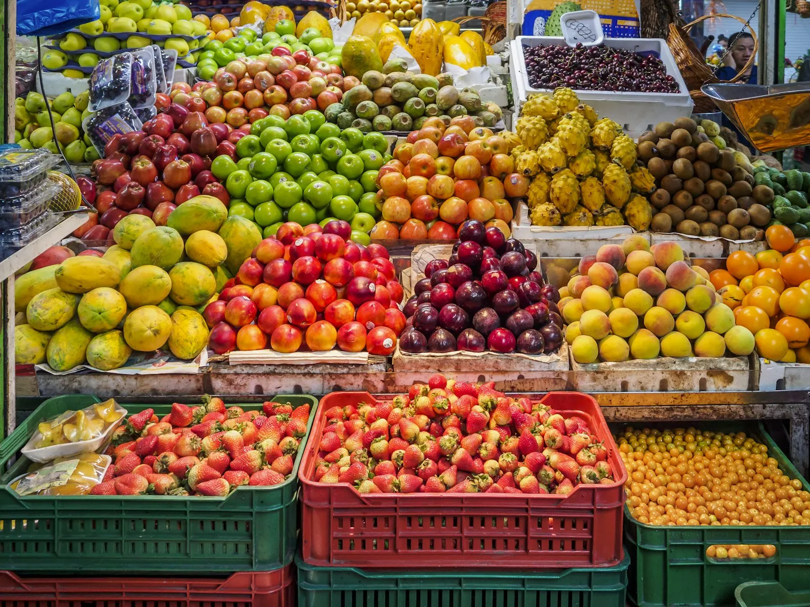 Crates of fresh apples, plums and strawberries